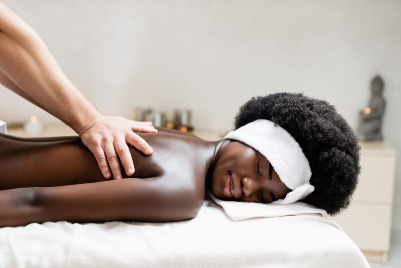 A relaxed woman happily sleeping while doing some swedish massage to her,