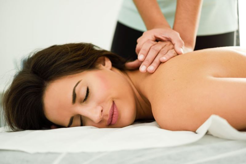 A woman wants a full-body massage and started the therapist to massage at the back.